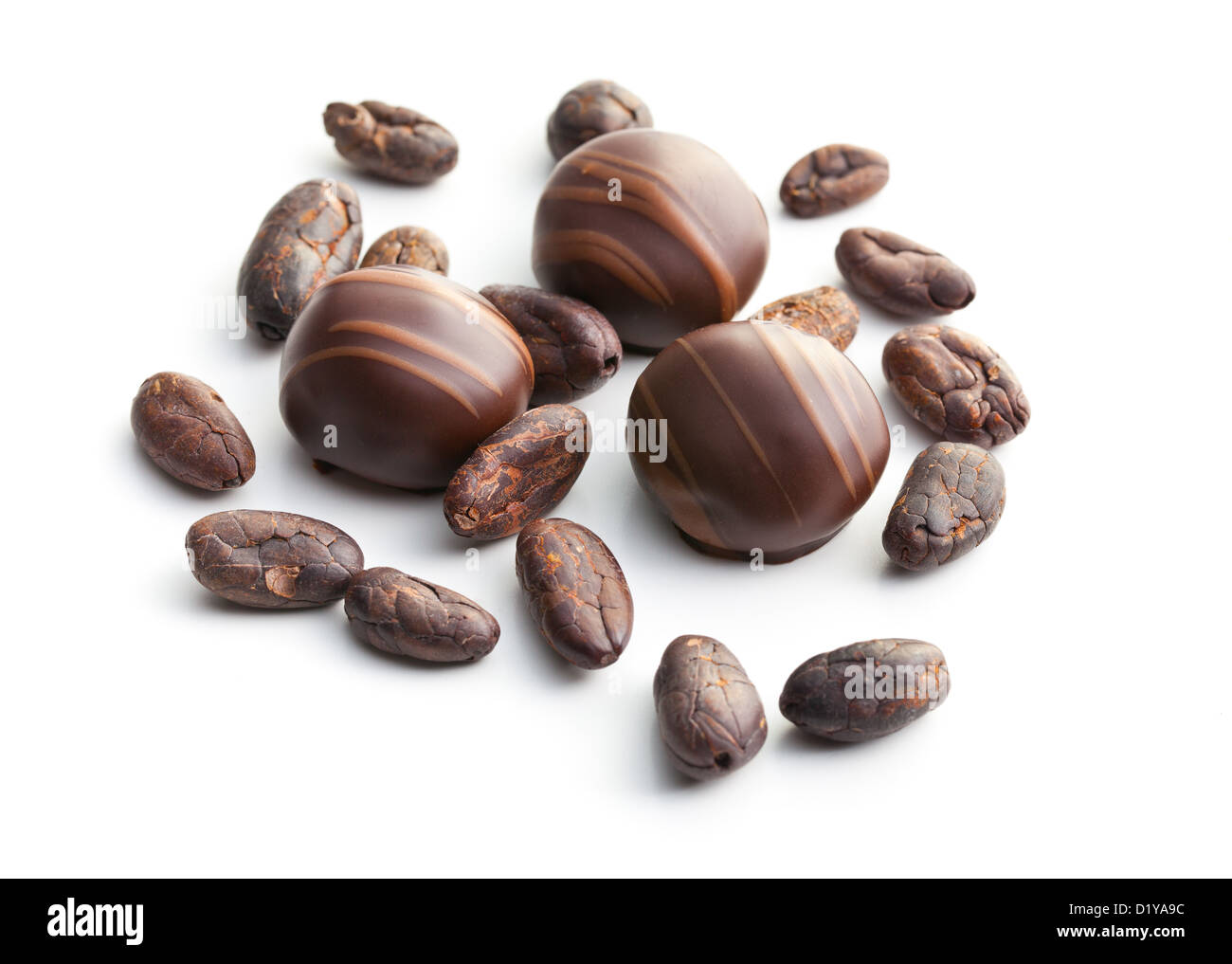 chocolate pralines and cocoa beans on white background Stock Photo