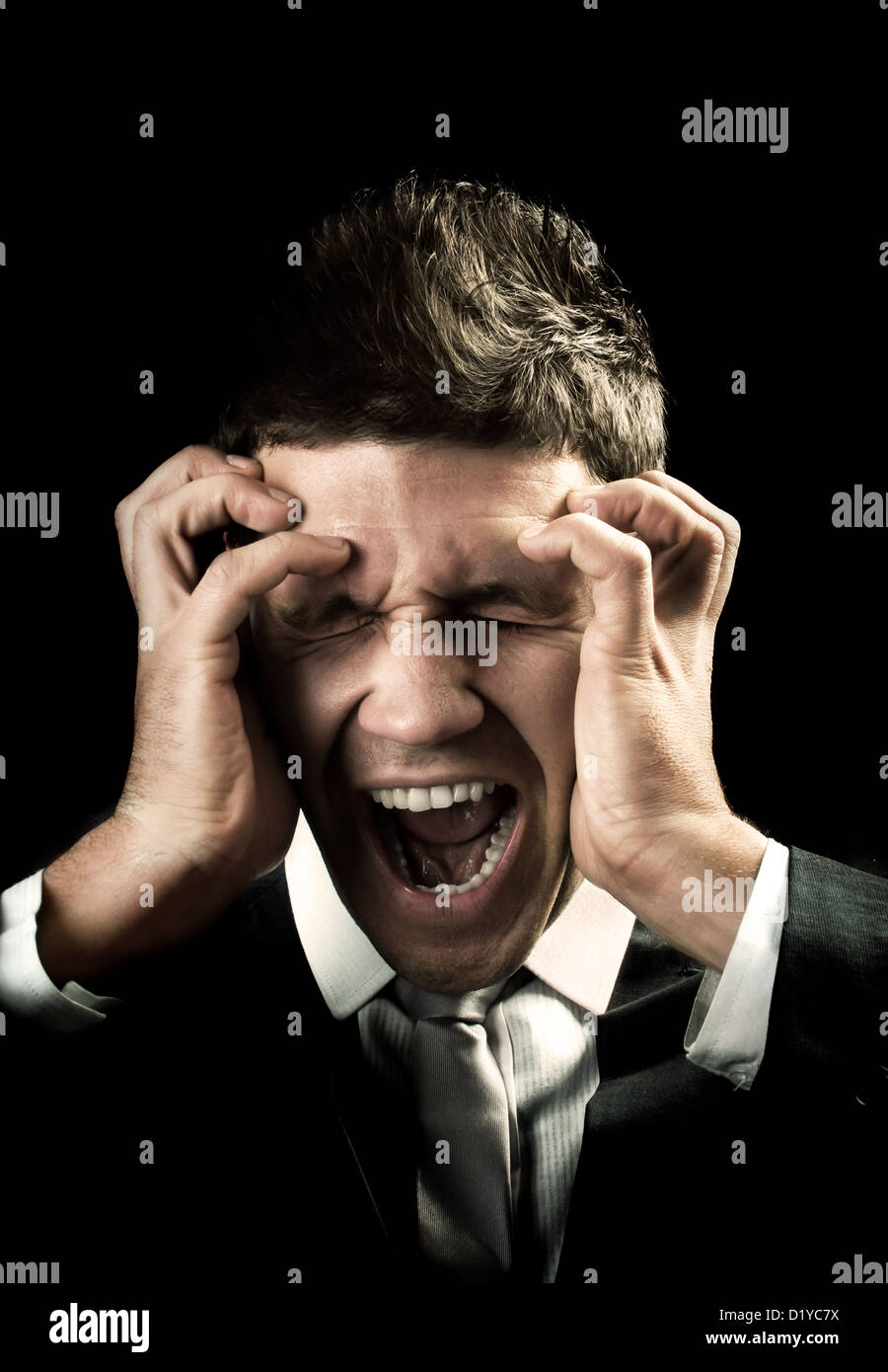 Businessman screaming and has a bad headache Stock Photo