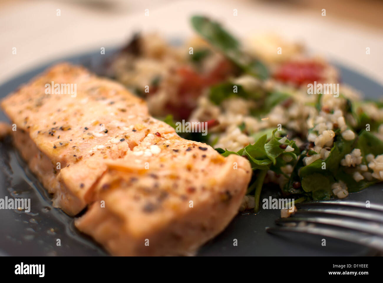 roasted salmon fillet with fresh green leaves salad and quinoa Stock Photo