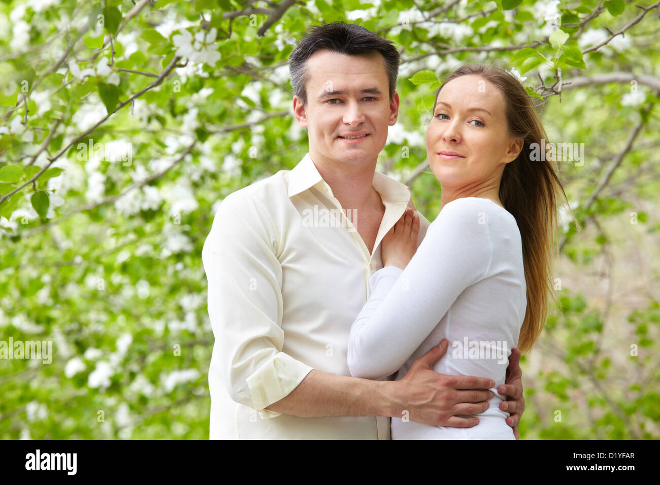Portrait of young couple looking at camera in park Stock Photo - Alamy