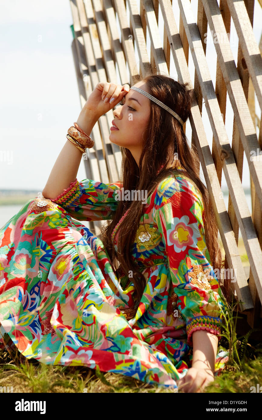 Portrait of pretty young lady in country clothing having rest outdoors Stock Photo