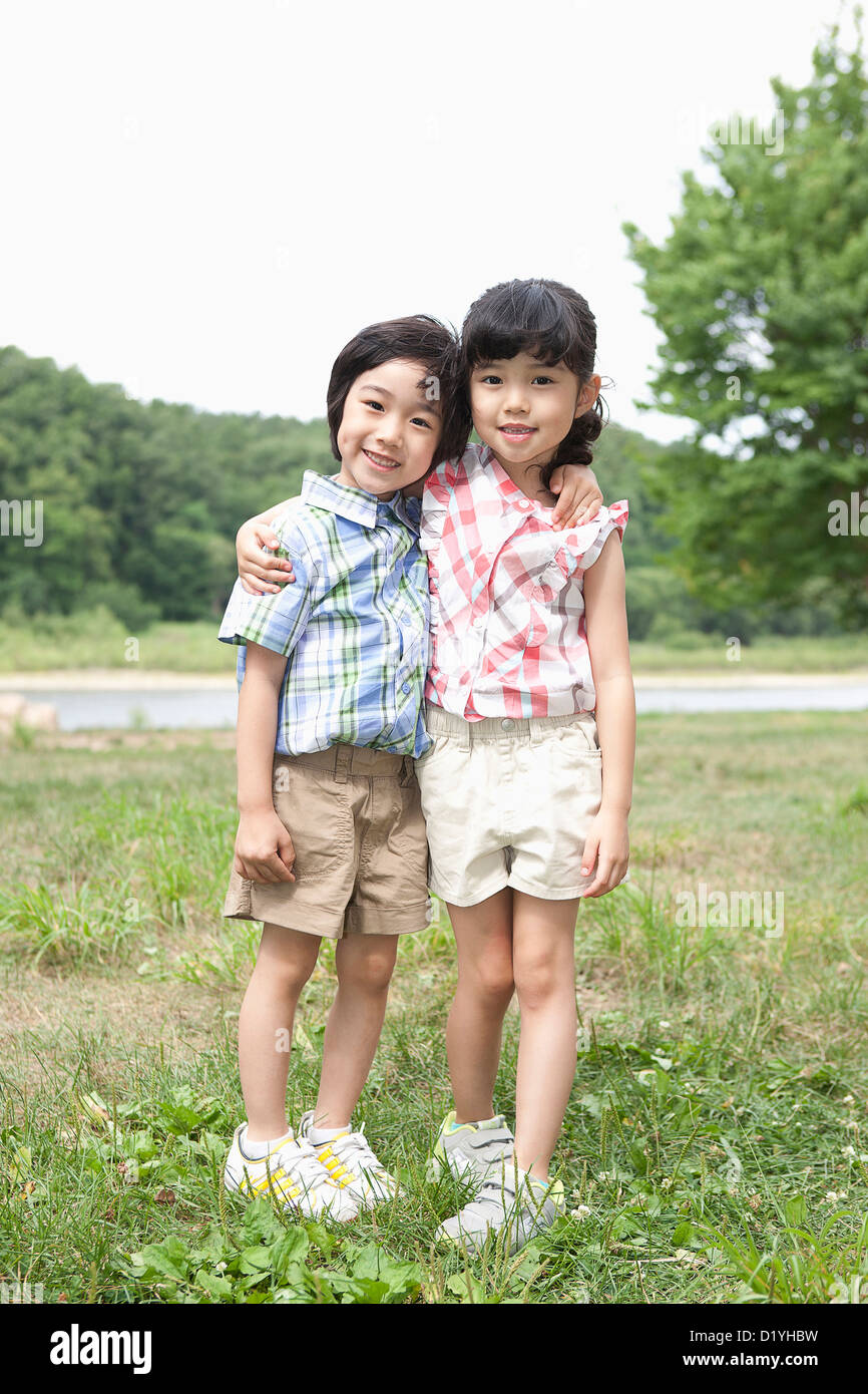 two kids standing with arms around each other Stock Photo - Alamy