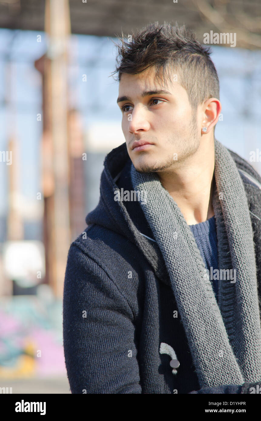 Handsome young man in urban or industrial setting, looking to a side Stock Photo