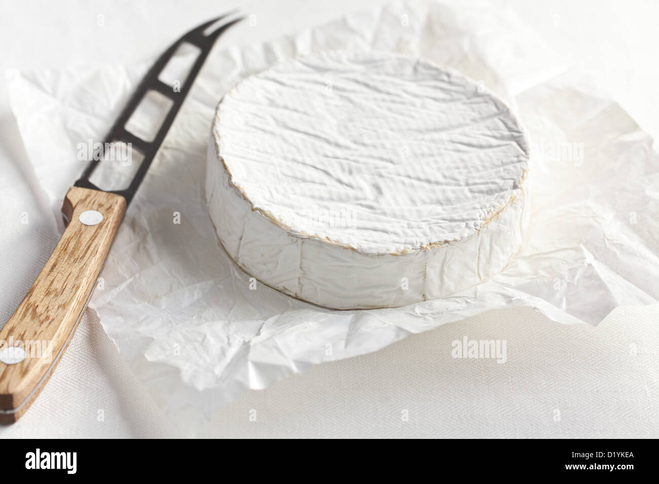 camembert cheese with knife on kitchen table Stock Photo