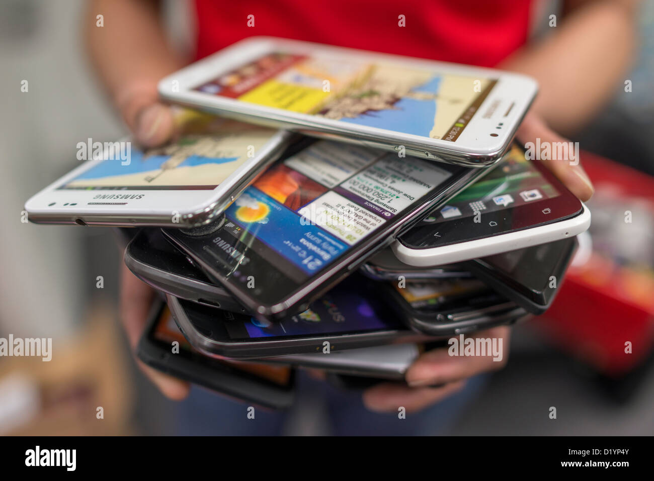Person holding a pile of phones. Stock Photo