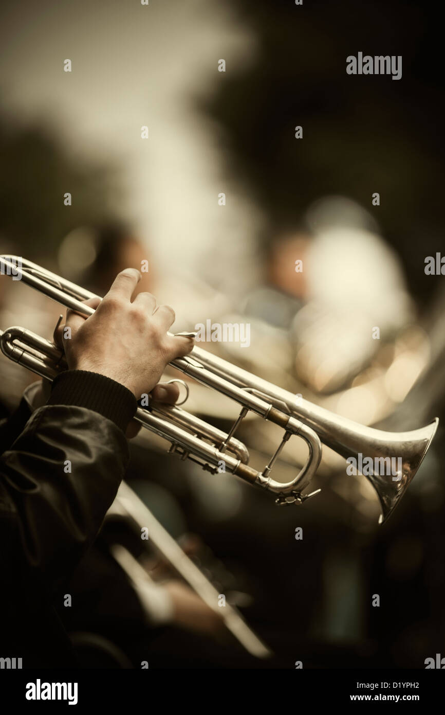 jazz band playing on the street, selective focus on the hands with trumpet ,film f/x Stock Photo