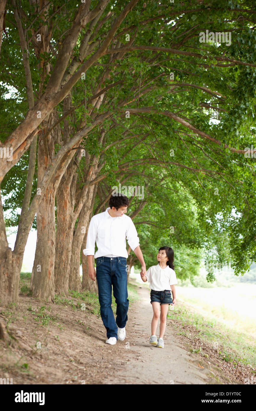 a father and a daughter taking a walk along trees Stock Photo - Alamy