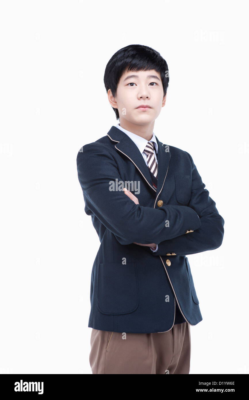 a male student wearing school uniform standing with arms crossed Stock