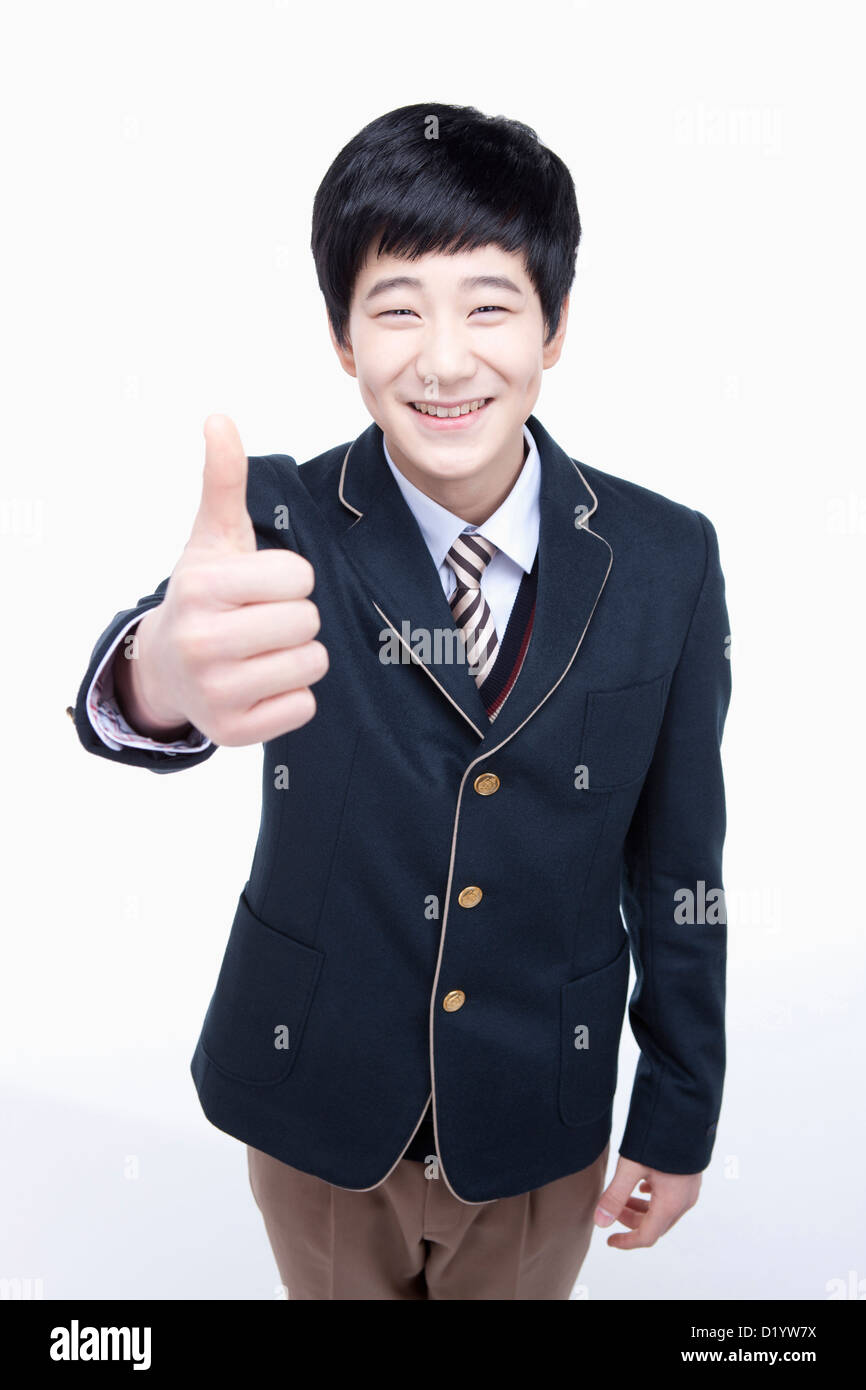 a male student wearing school uniform posing thumbs up Stock Photo - Alamy