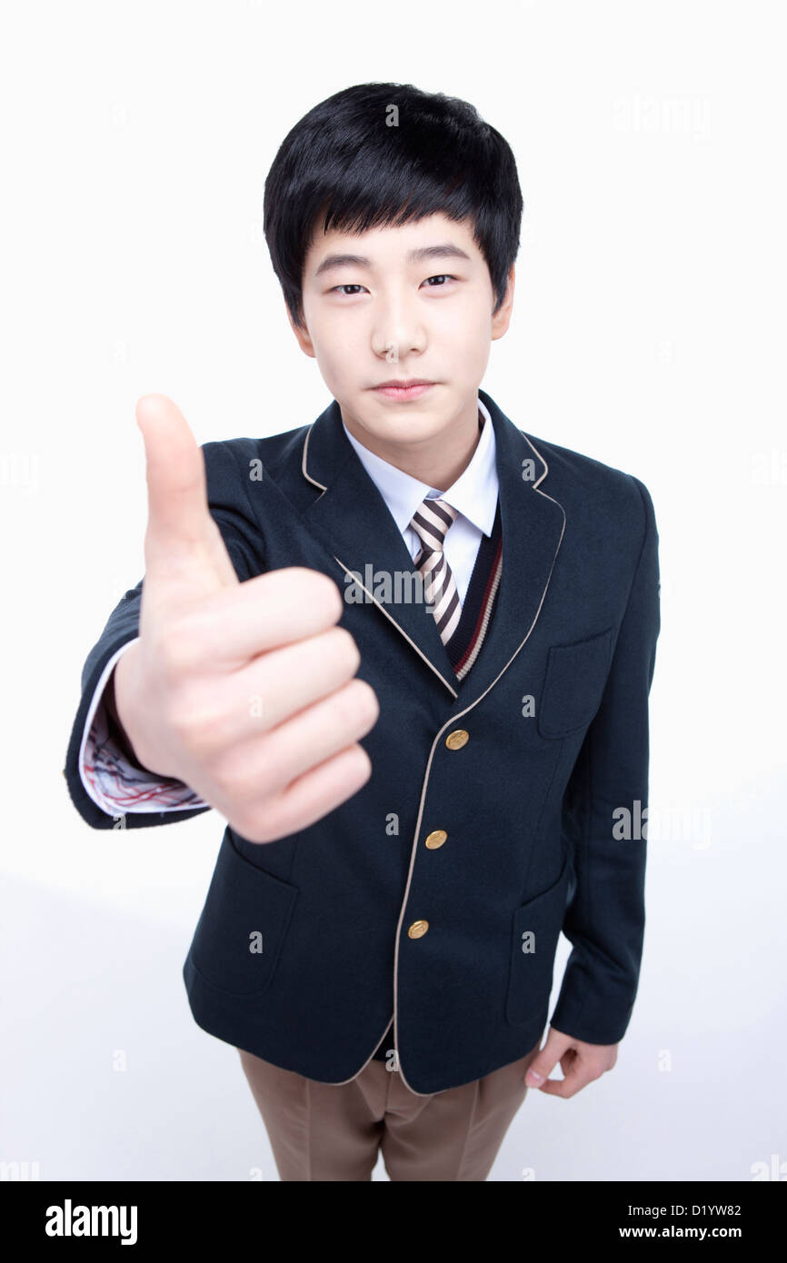 a male student wearing school uniform posing thumbs up Stock Photo - Alamy