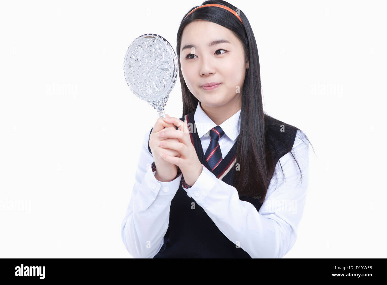 a female student wearing school uniform looking at herself through a ...