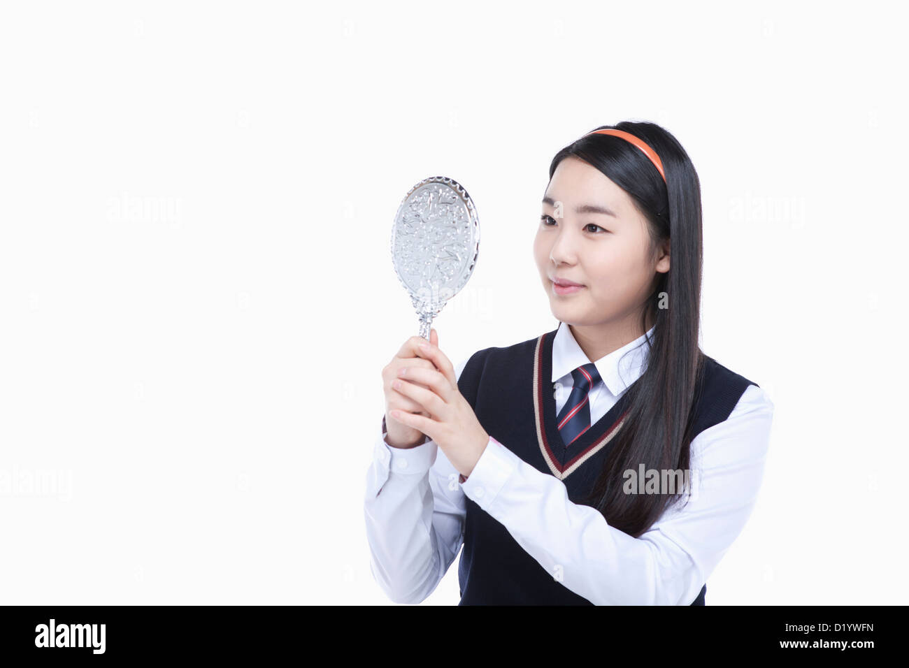 a female student wearing school uniform looking at herself through a ...