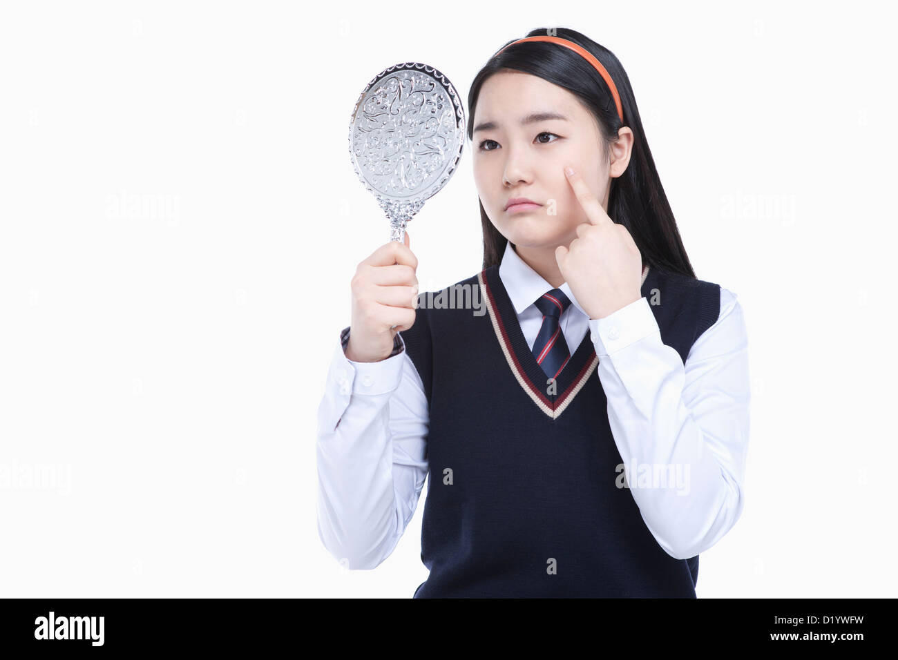 a female student wearing school uniform looking at herself through a ...