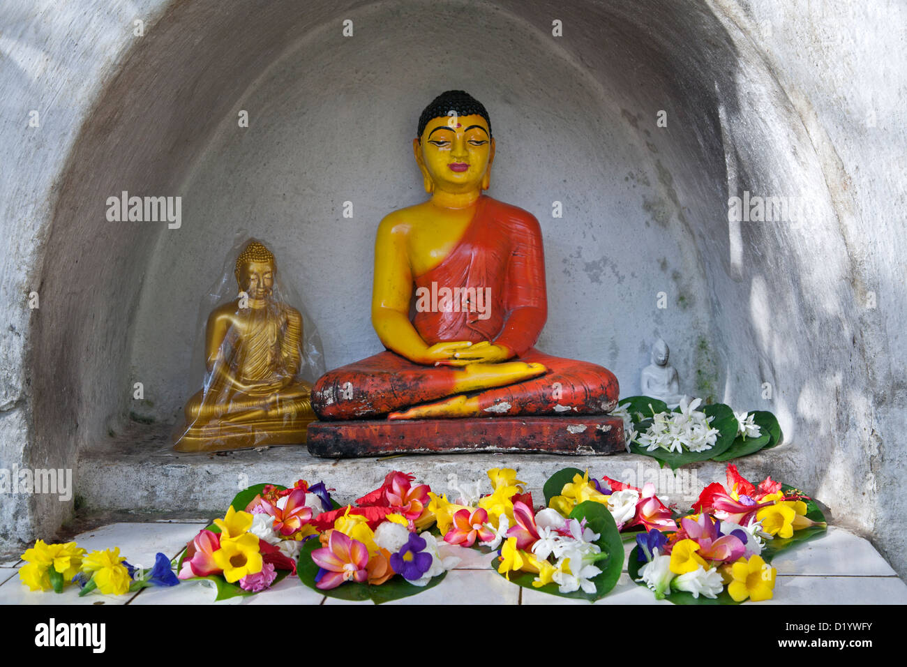 Buddha sculpture and flower offerings. Temple of the Sacred Tooth Relic. Kandy. Sri Lanka Stock Photo