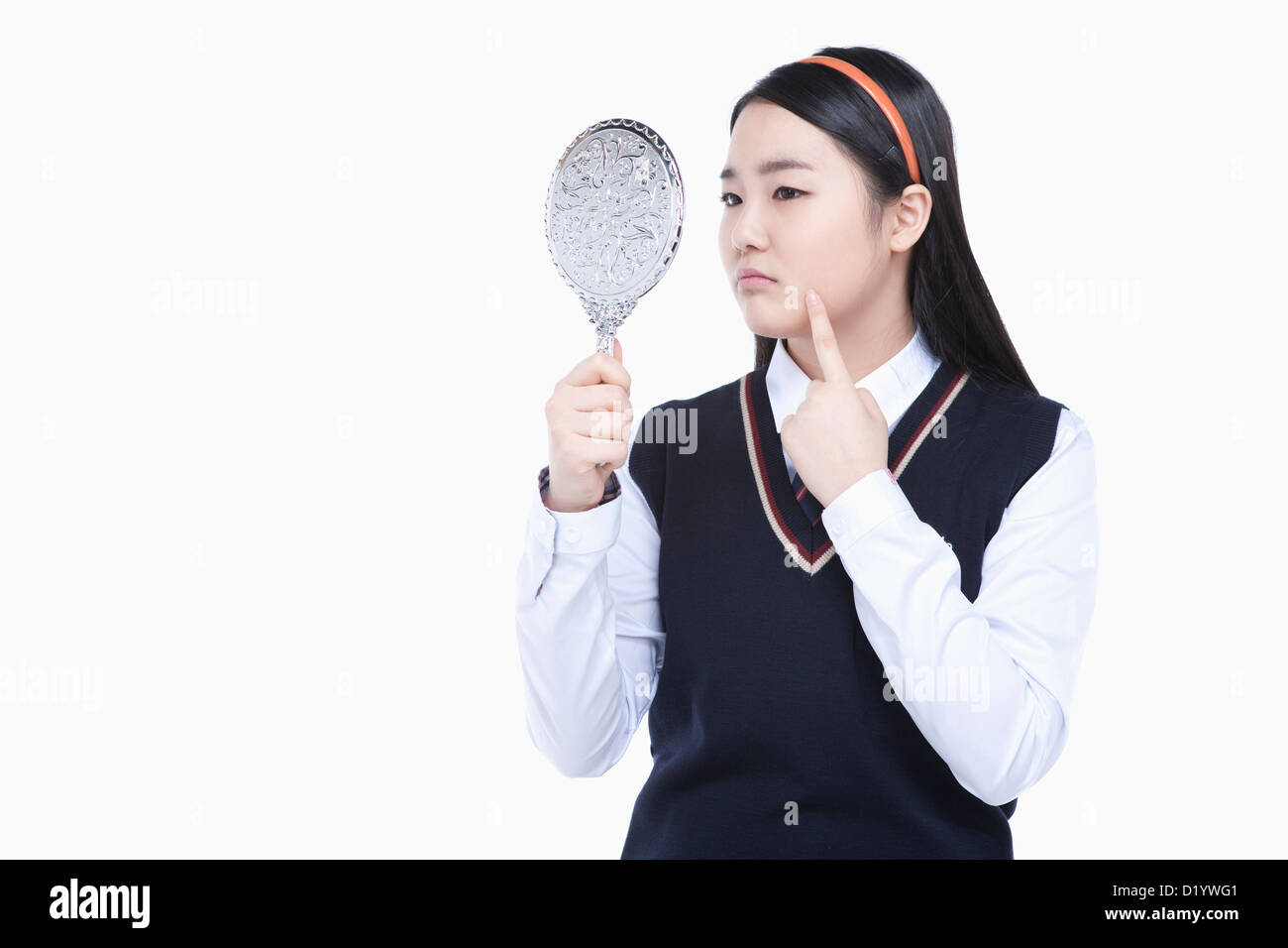 a female student wearing school uniform looking at herself through a ...
