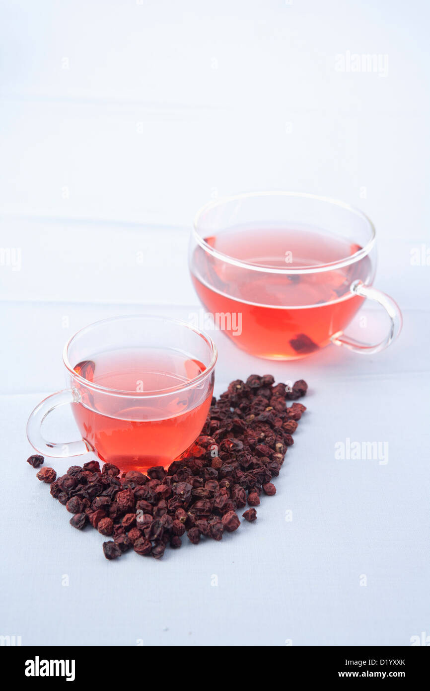 two cups of omija tea and fruit of Maximowiczia typica Stock Photo