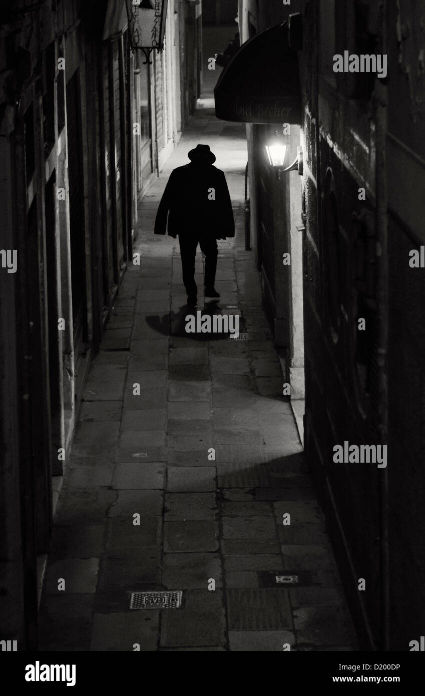 One man at night in Alley, Venice, Italy Stock Photo