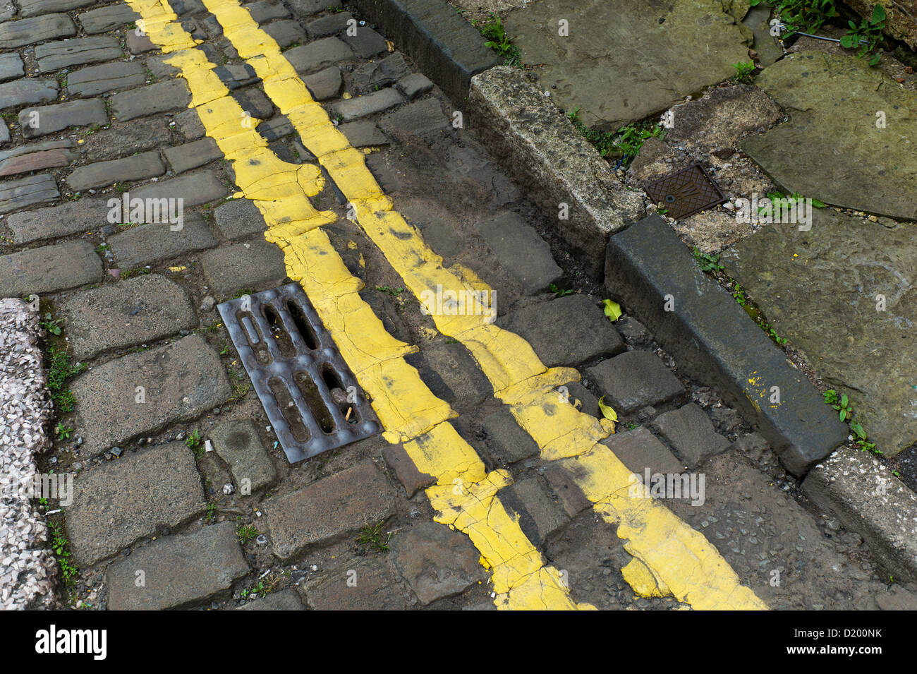 Yellow lines on old cobbled street, Oldham, Greater Manchester Lancashire Stock Photo