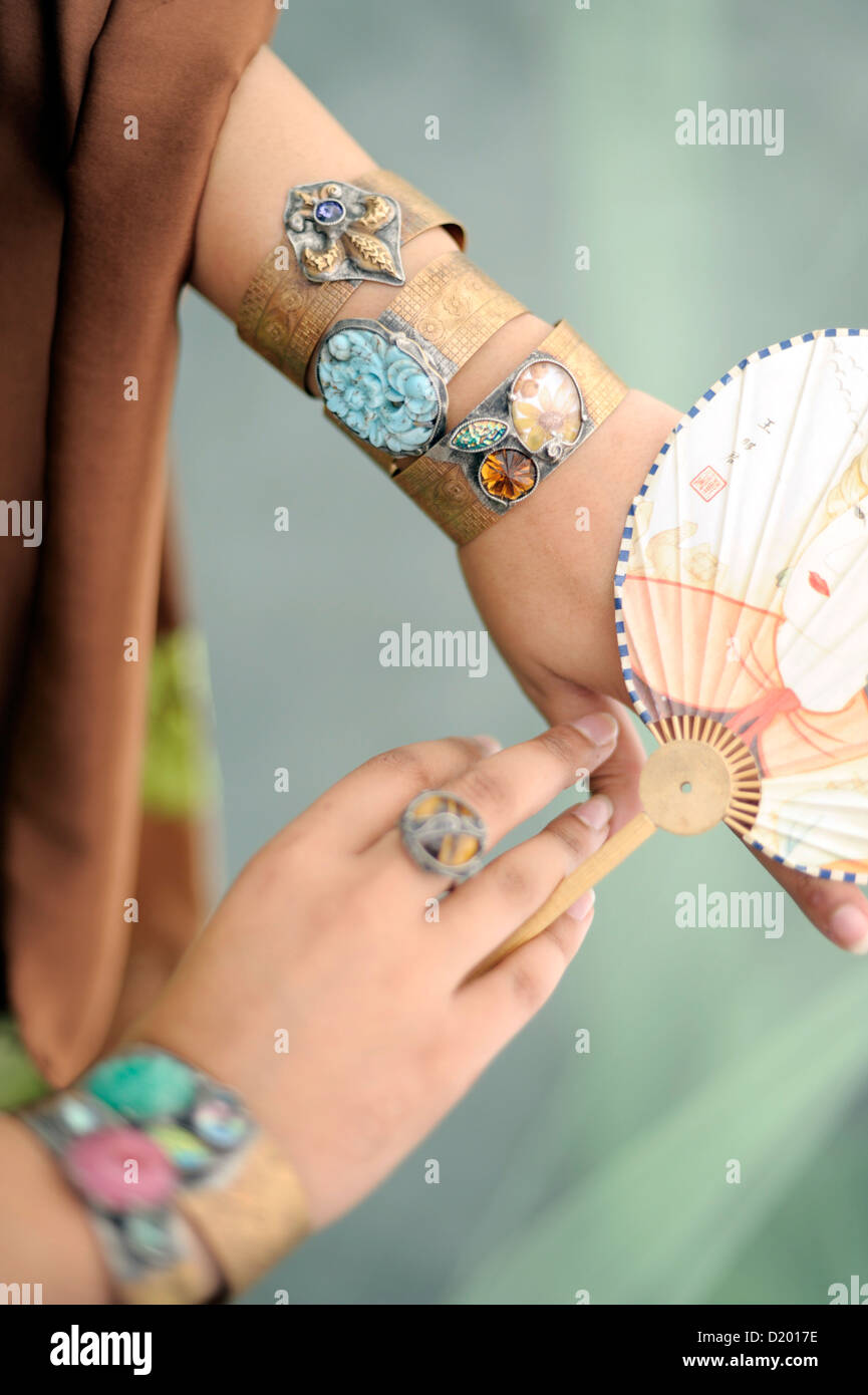 Beautiful Woman asian woman wearing a kimono adorned with jewelry artistically posed. Feminine Spring Goddess with flower and fan. Stock Photo