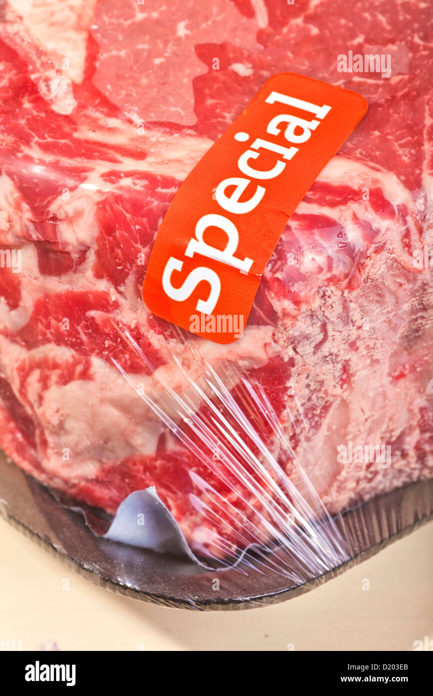 A prime rib roast packaged and wrapped in cellophane with a special sale sticker. Stock Photo
