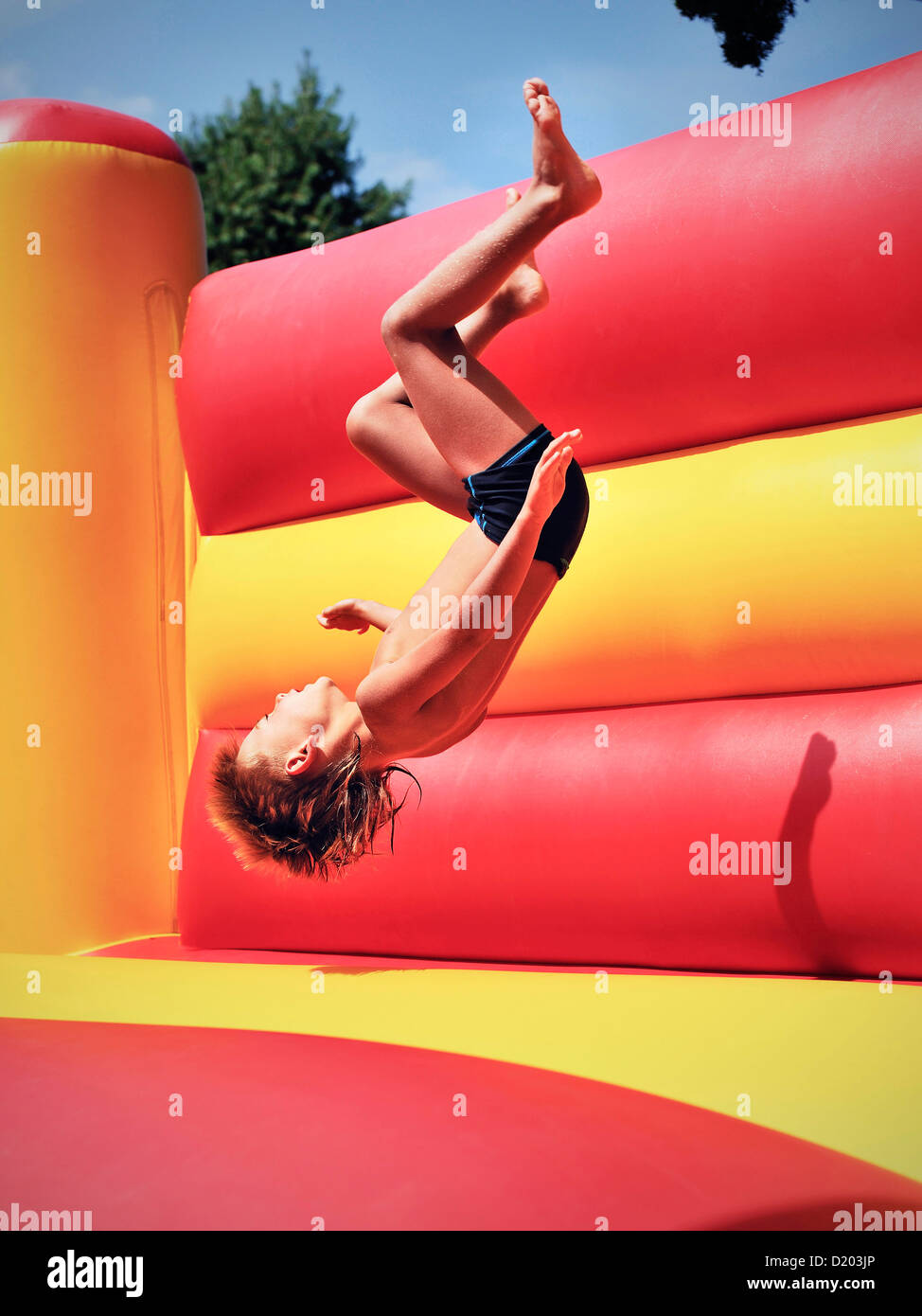 Young boy doing a somersault in a bouncy castle, Freibad Spiesel, Aalen