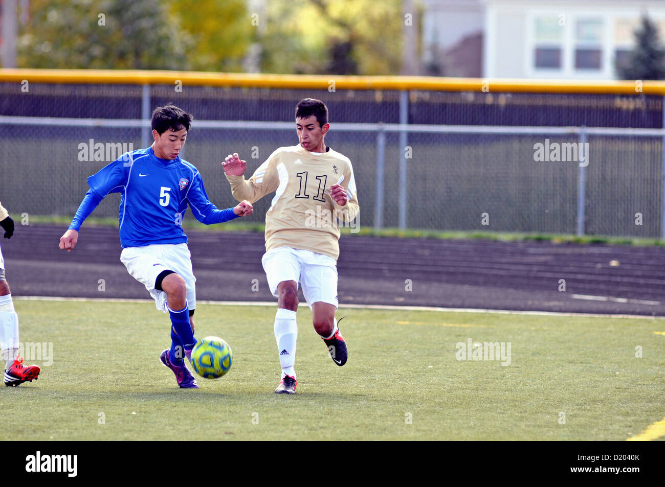 Soccer players compete in the corner deep at the end of the pitch during a high school match. USA. Stock Photo