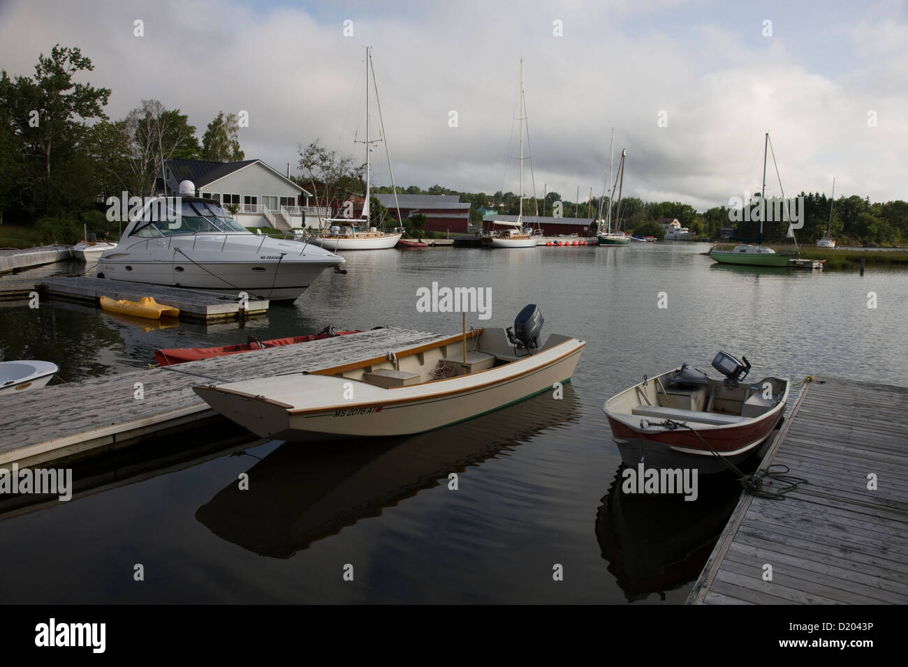 Boats and yachts moored on he shore of the Bras d'Or Lake in the Inverary Resort, Baddeck, Nova Scotia Stock Photo