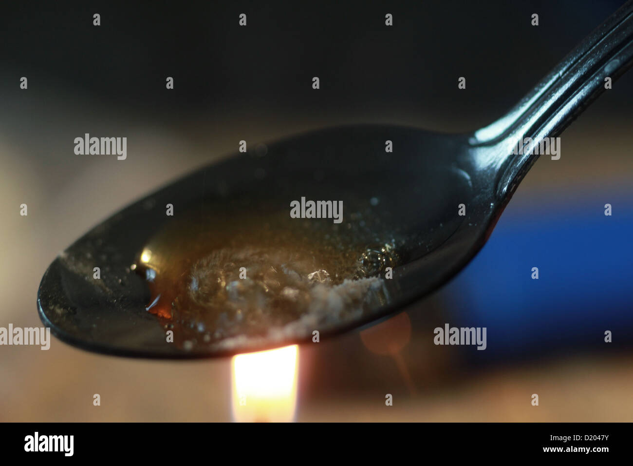 Cooking heroin on spoon over flame Stock Photo