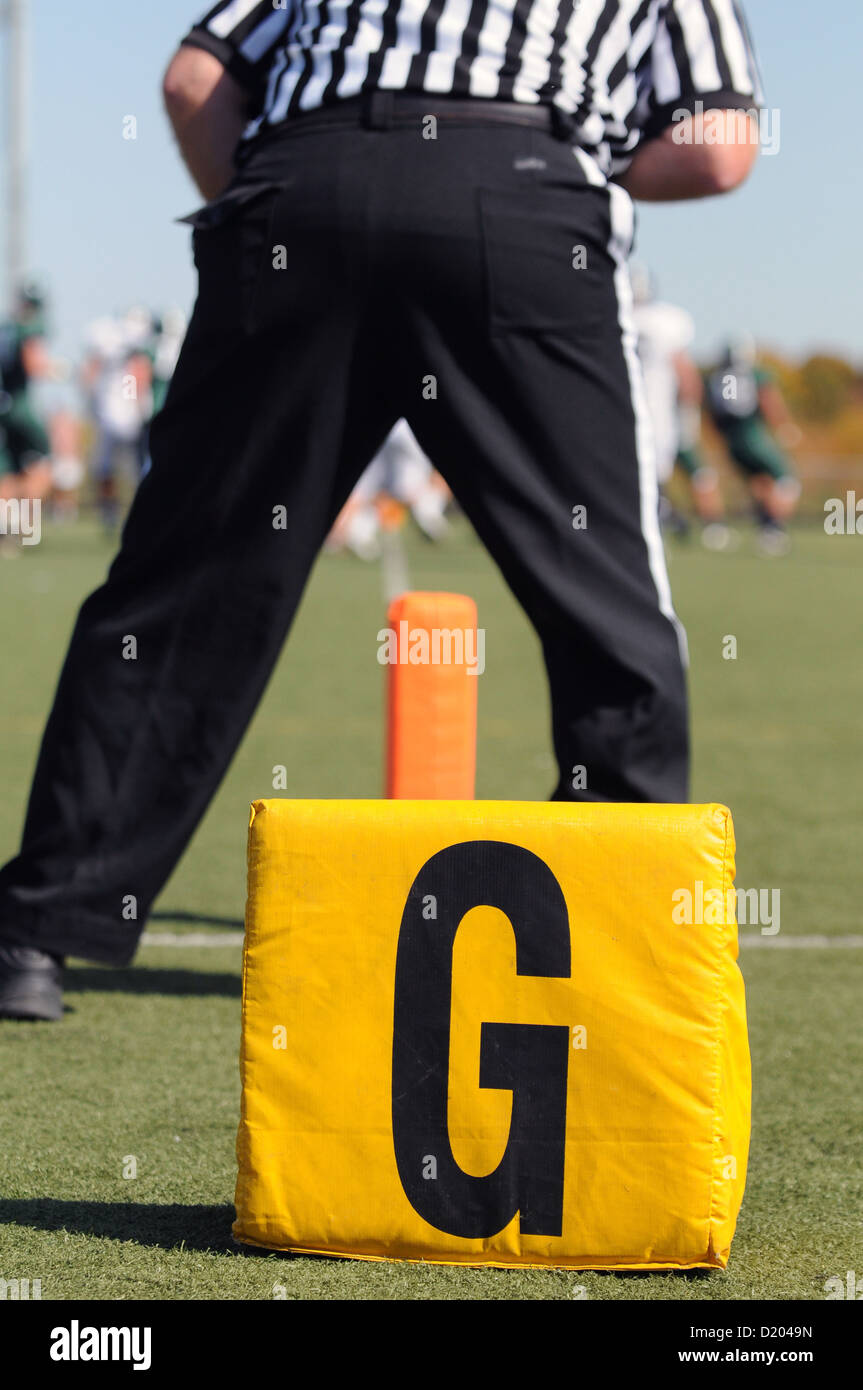 Football High school official straddles the goal line waiting to see if a touchdown will be scored on the field. USA. Stock Photo