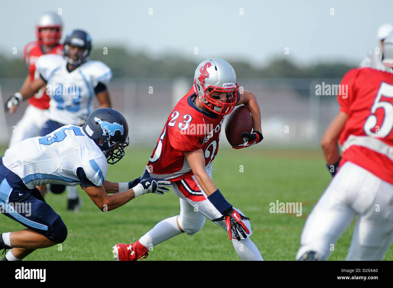 Football Wide receiver brought down by a jersey tackle during a high school game. USA. Stock Photo