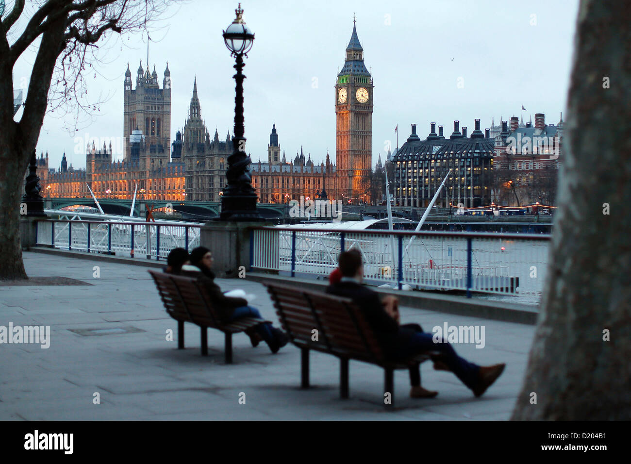 People sit and admire the view on the South Bank near Big Ben and the Houses of Parliament on 07 January 2013 in London. Stock Photo