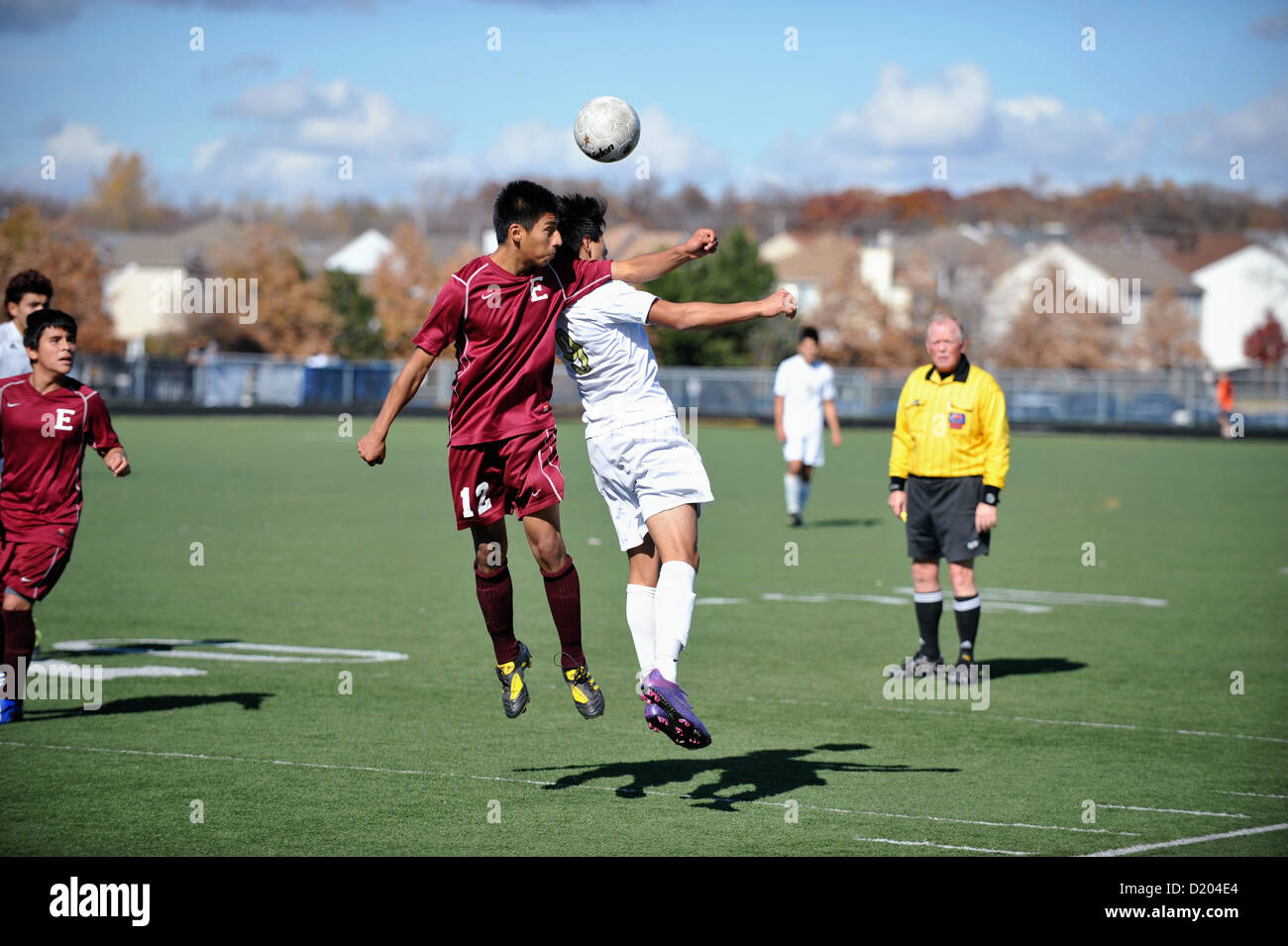 Soccer players battle for position for a header during a high school match. USA. Stock Photo