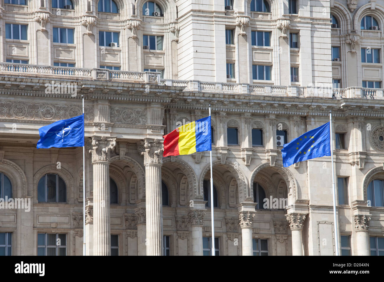 Bucharest, Romania, waving flags in front of the Palace of the Parliament Stock Photo