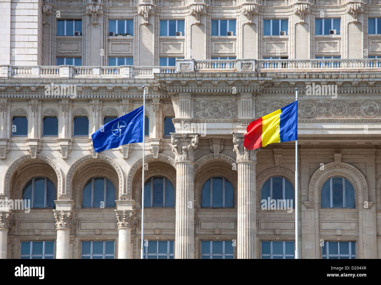 Bucharest, Romania, waving flags in front of the Palace of the Parliament Stock Photo