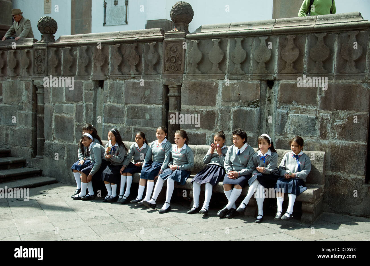 Smartly uniformed schoolgirls sitting on a bencn in the Plaza de la Independencia Quito Stock Photo