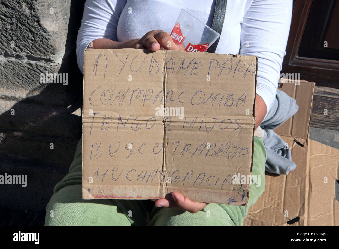 'Help me to buy food, I have children. I am looking for work. Thank you.' Young woman begging Puerto de la Cruz Stock Photo