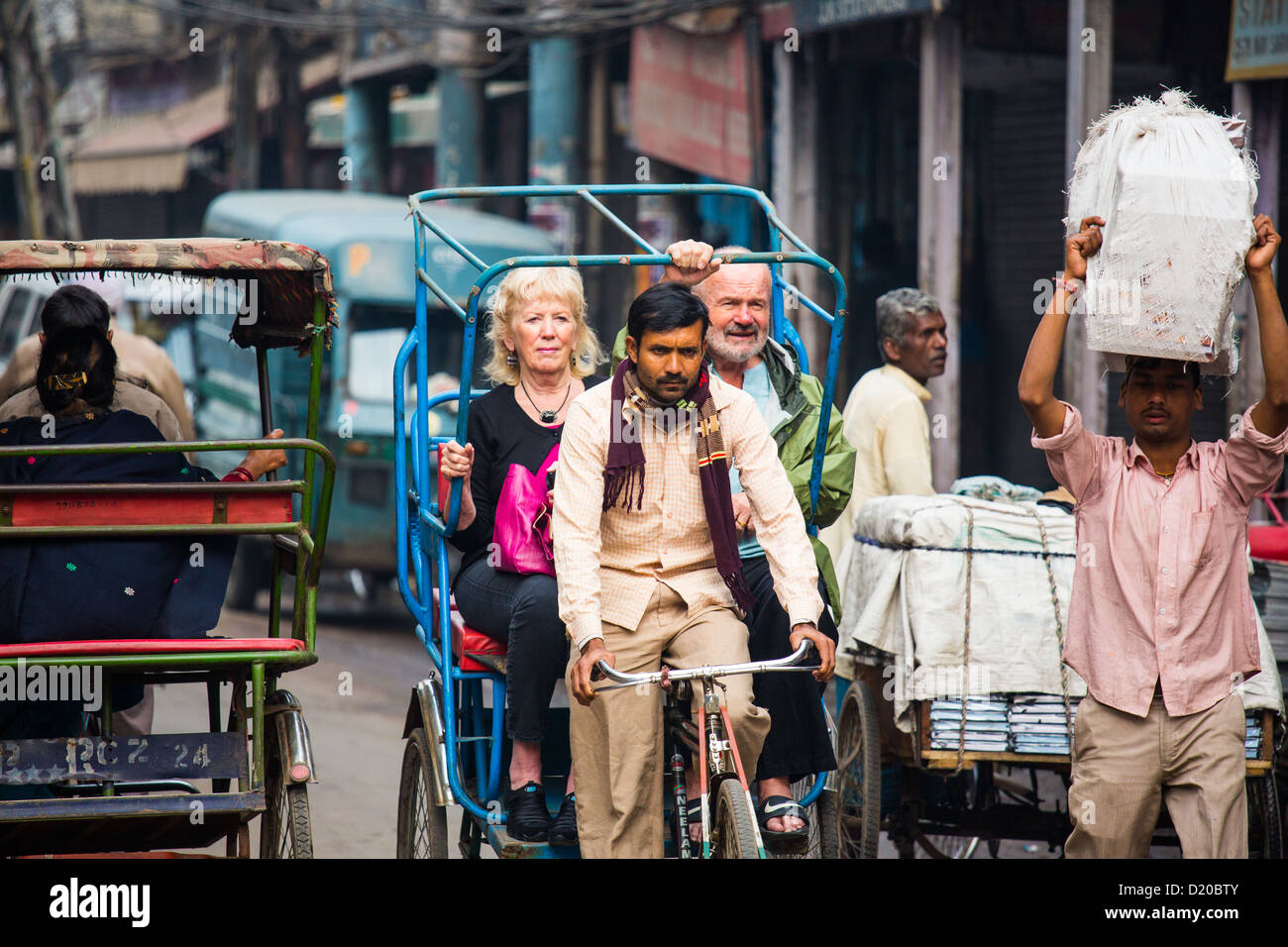 Tourists on a bicyce rickshaw in Old Delhi, India Stock Photo
