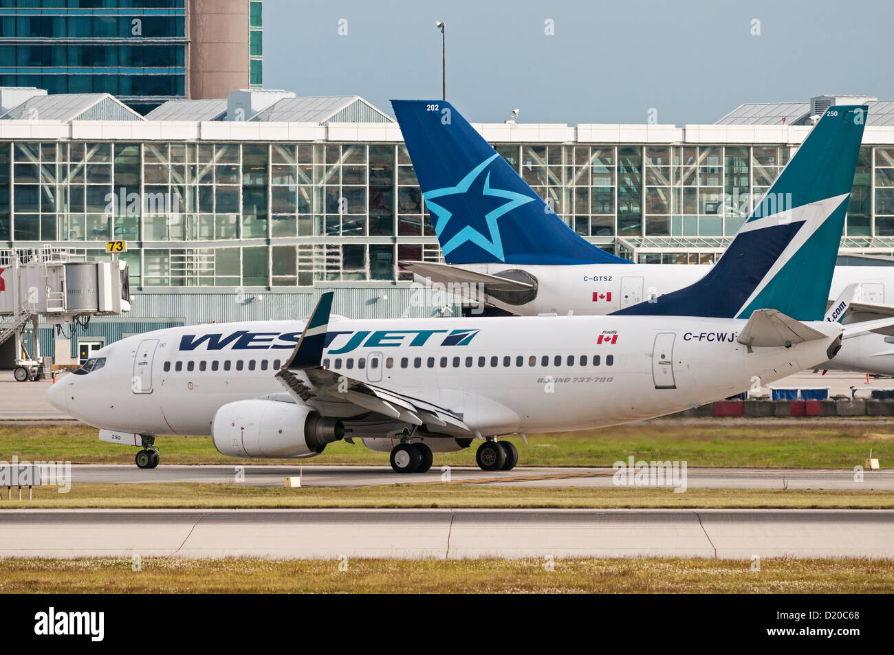 A Westjet Boeing 737 jetliner taxies by an Air Transat Airbus A330 jetliner on the tarmac at Vancouver International Airport Stock Photo
