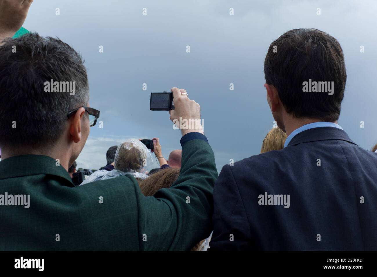 Man in crowd photographing event Stock Photo