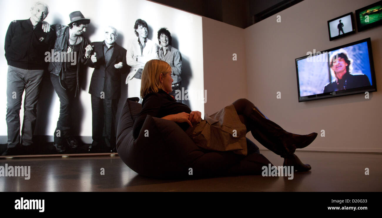 A woman sits in front of a photo showing the director Scorsese and The Rolling Stones whcih was taken during the shooting of 'Shine a Light' exhibited at the 'Martin Scorsese' exhibition at the Museum for Film and Television in Berlin, Germany, 09 January 2013. The exhibition is running from 10 January until 12 May. Photo: JOERG CARSTENSEN Stock Photo