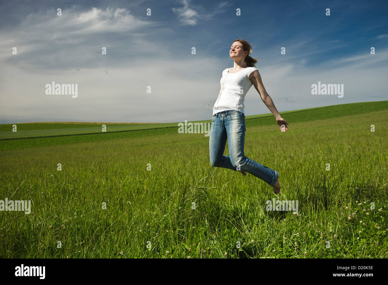 Girl jumping barefoot in a meadow, Upper Bavaria, Germany Stock Photo