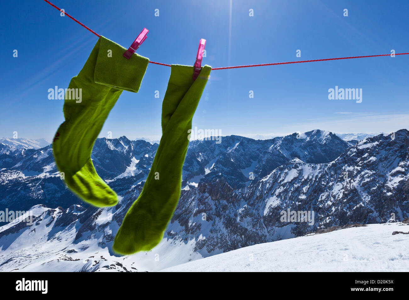 Green socks on clothesline in the sunlight, view onto Wetterstein and Karwendel mountains, Alpspitze, Alps, Bavaria, Germany, Eu Stock Photo