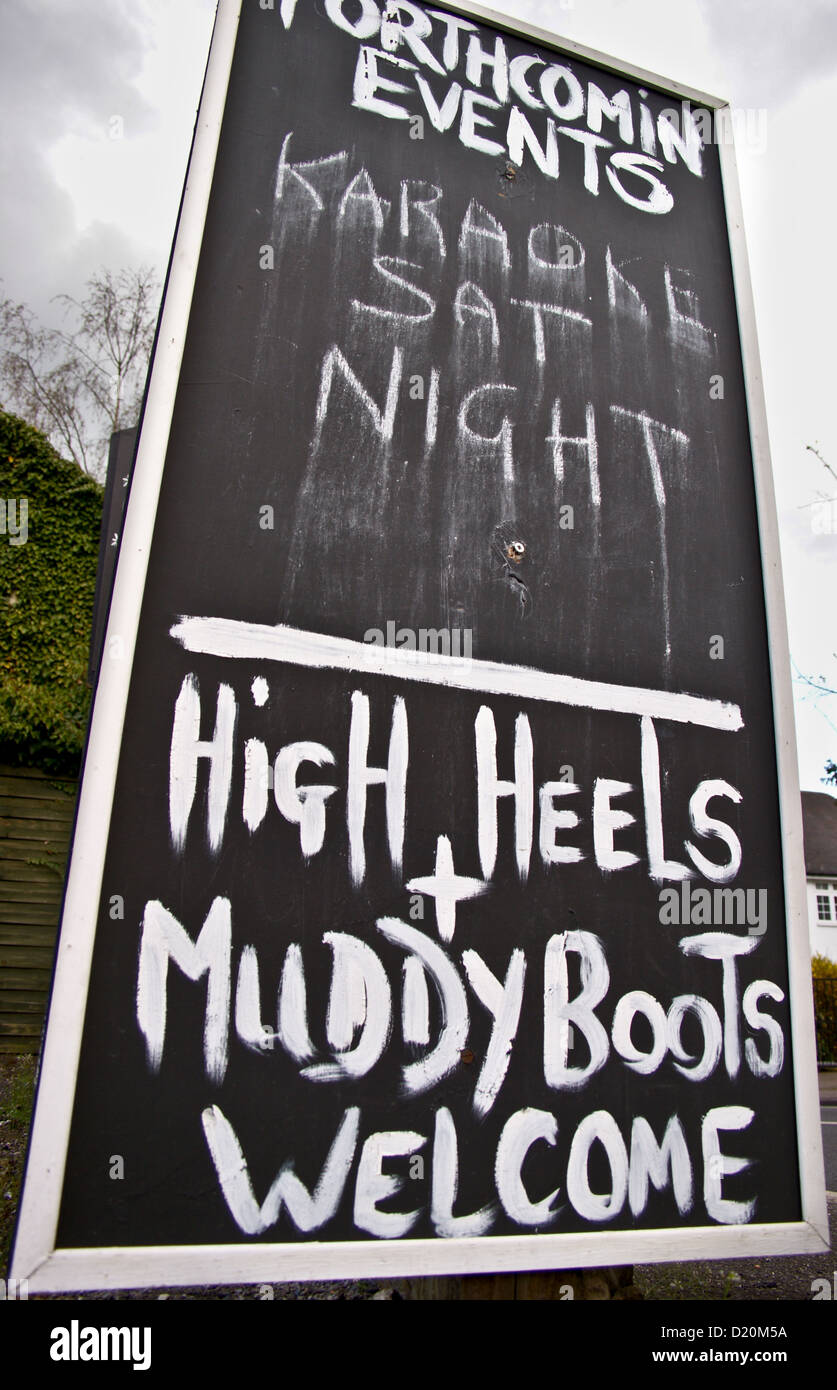 'High heels and Muddy boots welcome' and karaoke sign outside a pub in Essex, England Stock Photo