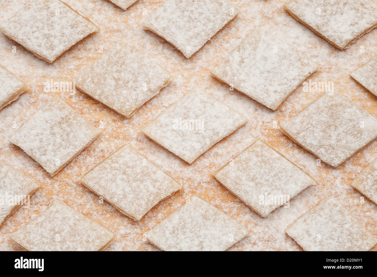 cut square homemade pasta strewed with flour or pasta background Stock Photo