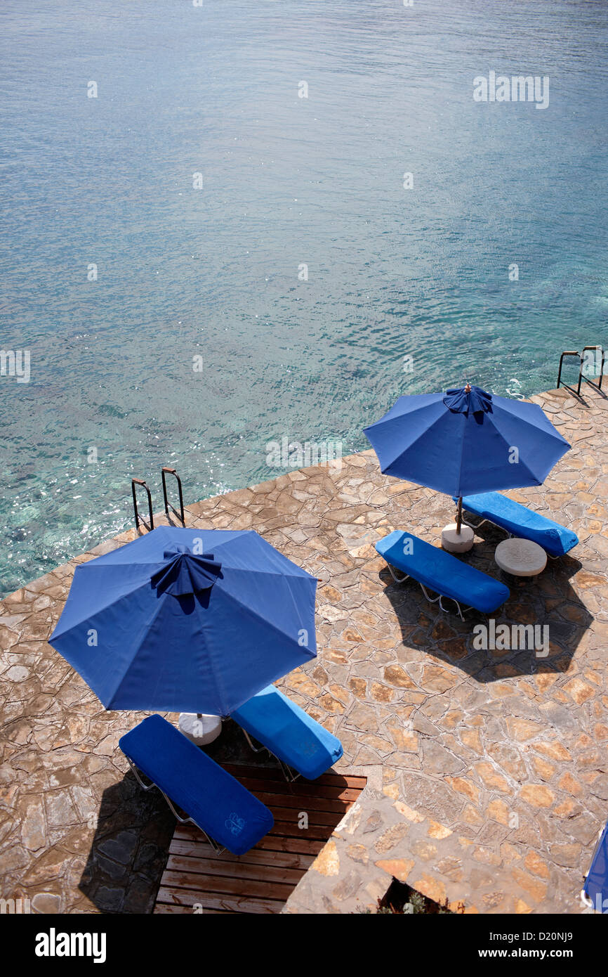 Sunshades and deck chairs at the seasite, Elounda, Agios Nikolaos, Crete, Greece Stock Photo