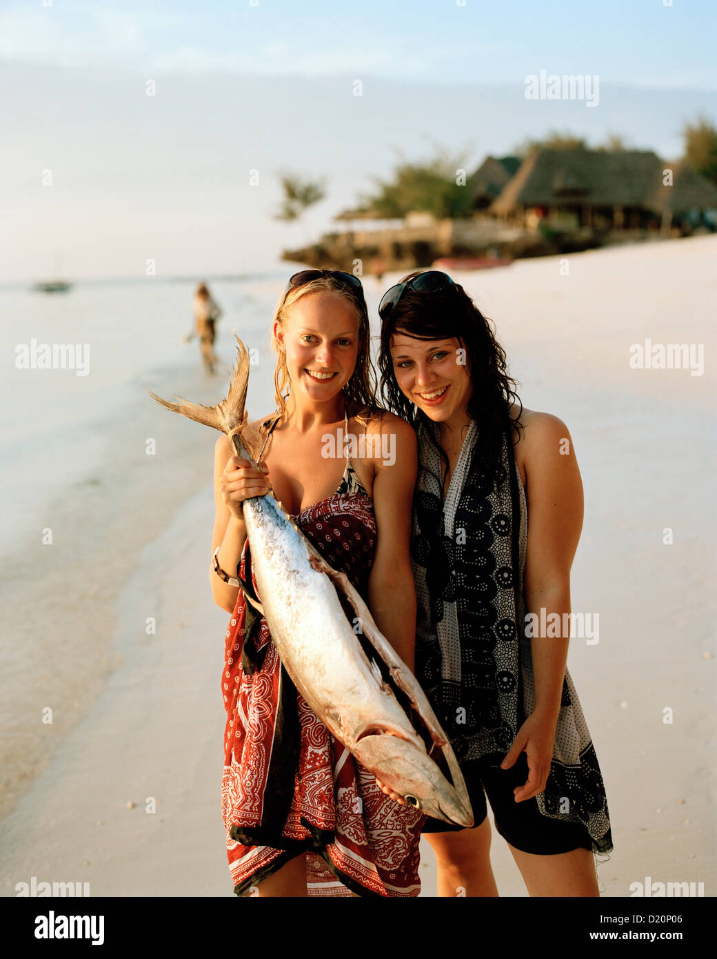 Tourists with bought Yellowtail Tuna for a birthday party, Nungwi, Zanzibar, Tanzania, East Africa Stock Photo