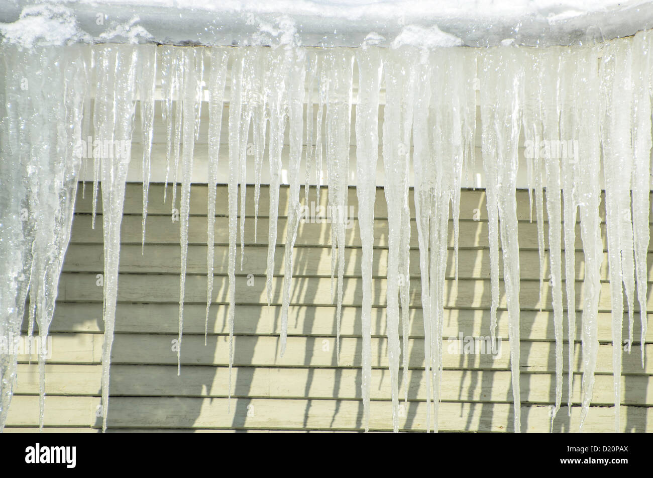 Icecicles hanging off of roof in winter Stock Photo