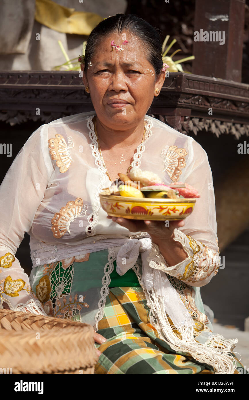 BALI - FEBRUARY 1. Priest's wife with fruit offering in temple for Galungan ceremony on February 1, 2012 in Bali, Indonesia. Stock Photo