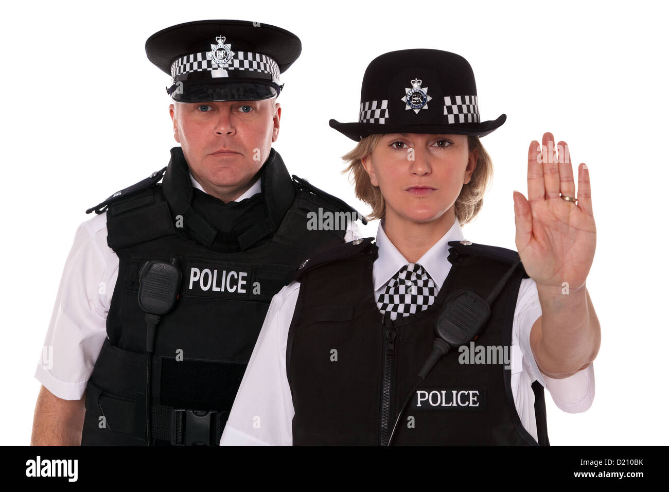 Studio shot of male and female British Police officers in uniform wearing body armour. The WPC is signalling Stop. Stock Photo