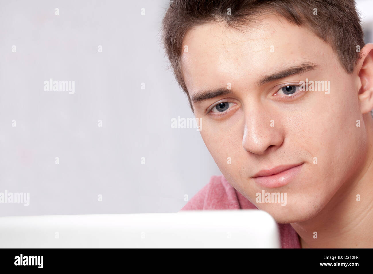 Close up shot of a young male using a laptop or digital tablet. Stock Photo